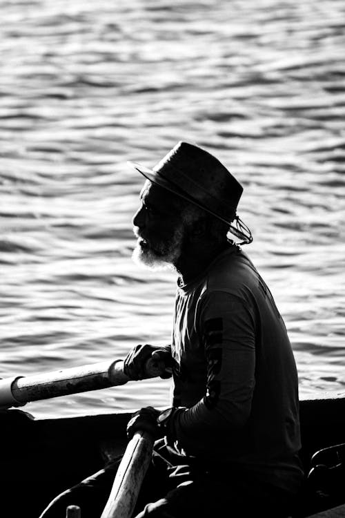 Silhouette of a fisherman rowing a boat on calm waters near Ahmedabad, reflecting a peaceful romantic escape