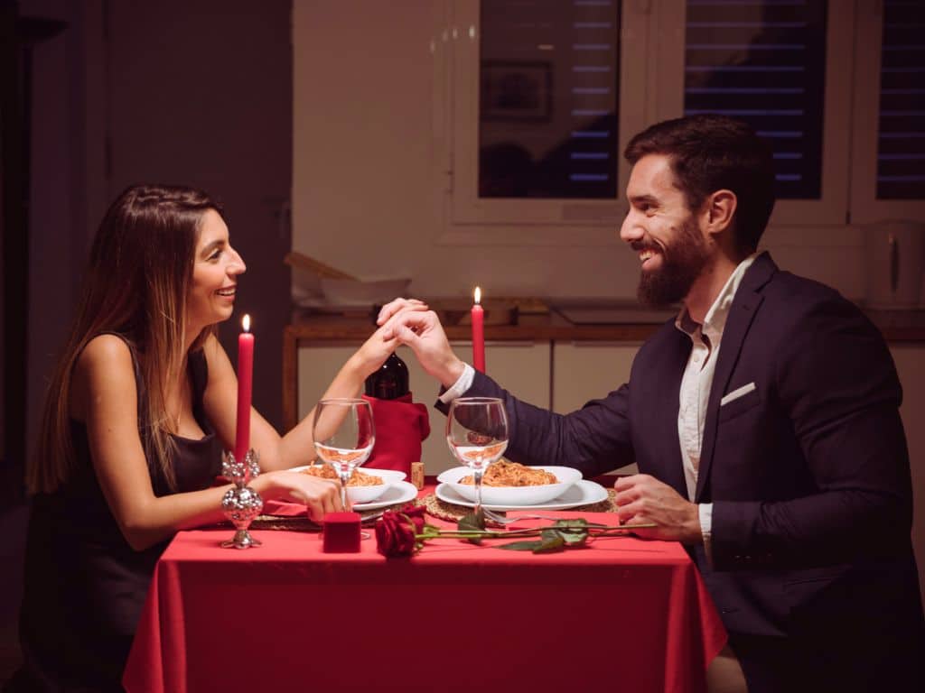 Couple enjoying a romantic candlelight dinner date at a restaurant in Ahmedabad.
