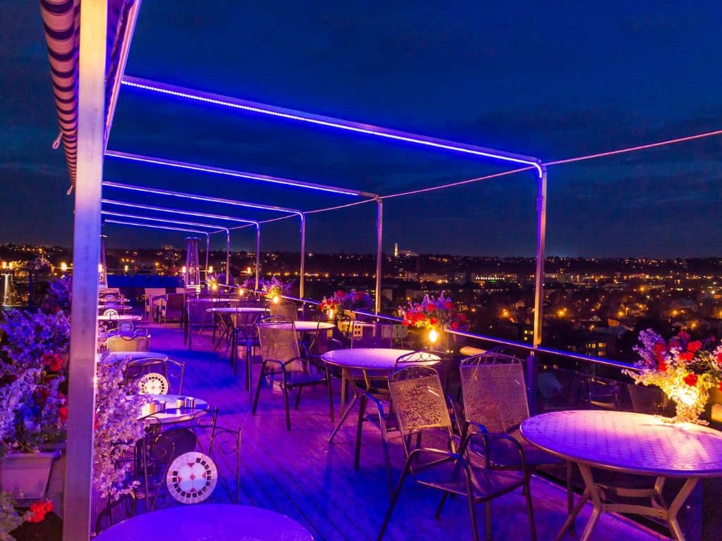 Romantic rooftop restaurant with city view and ambient night lighting.