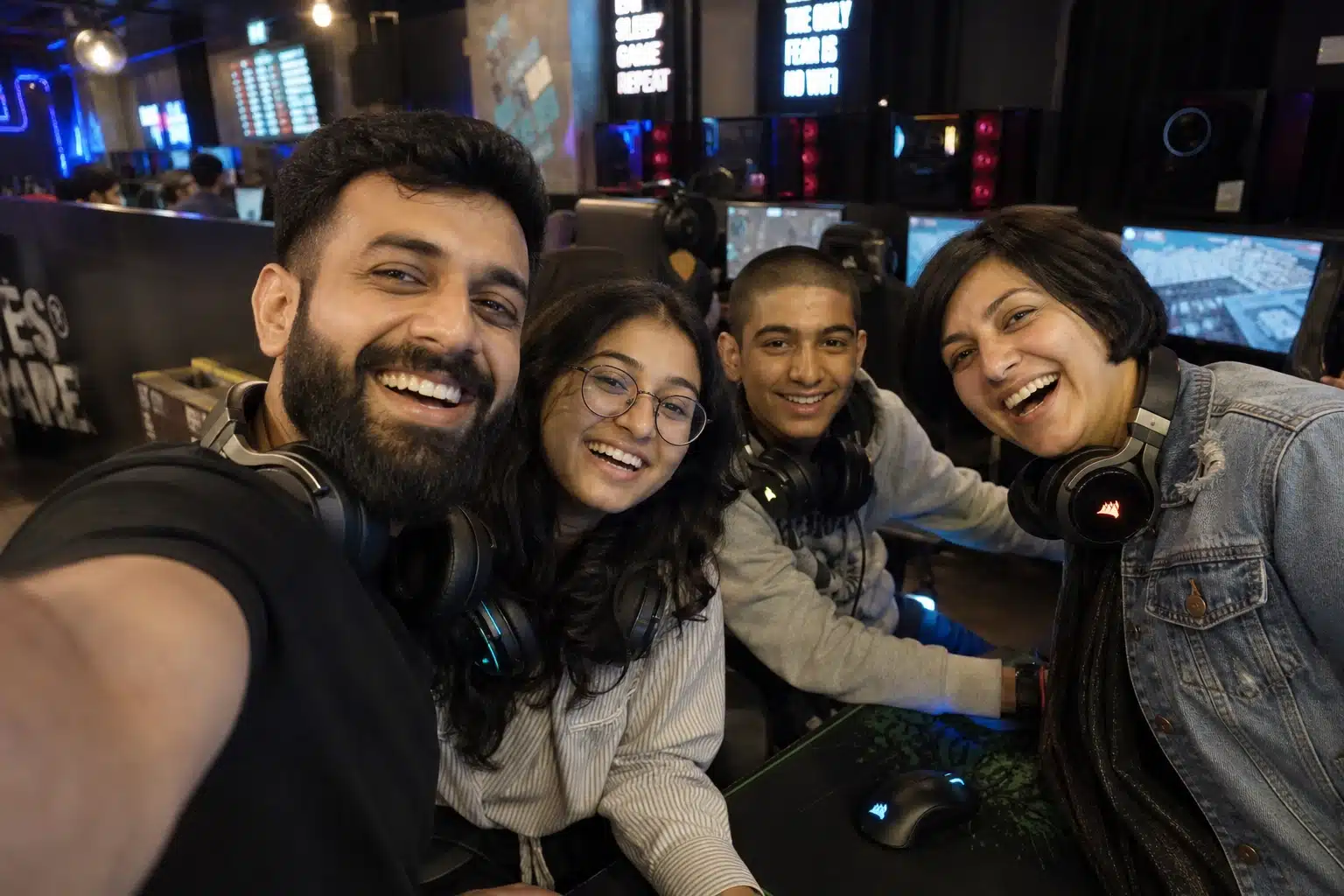 Friends taking a selfie at a gaming cafe.