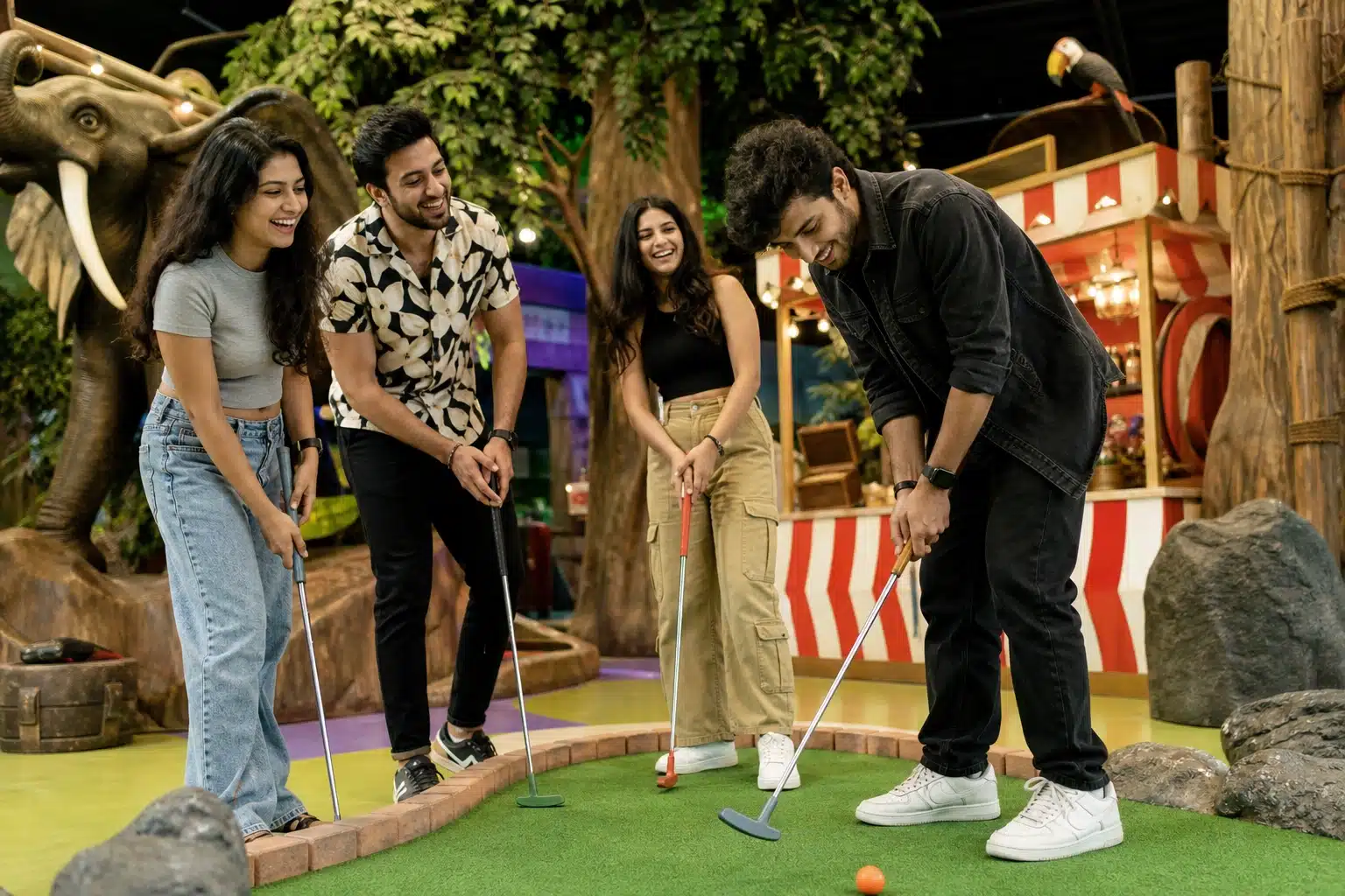 Friends playing mini golf on an indoor course.