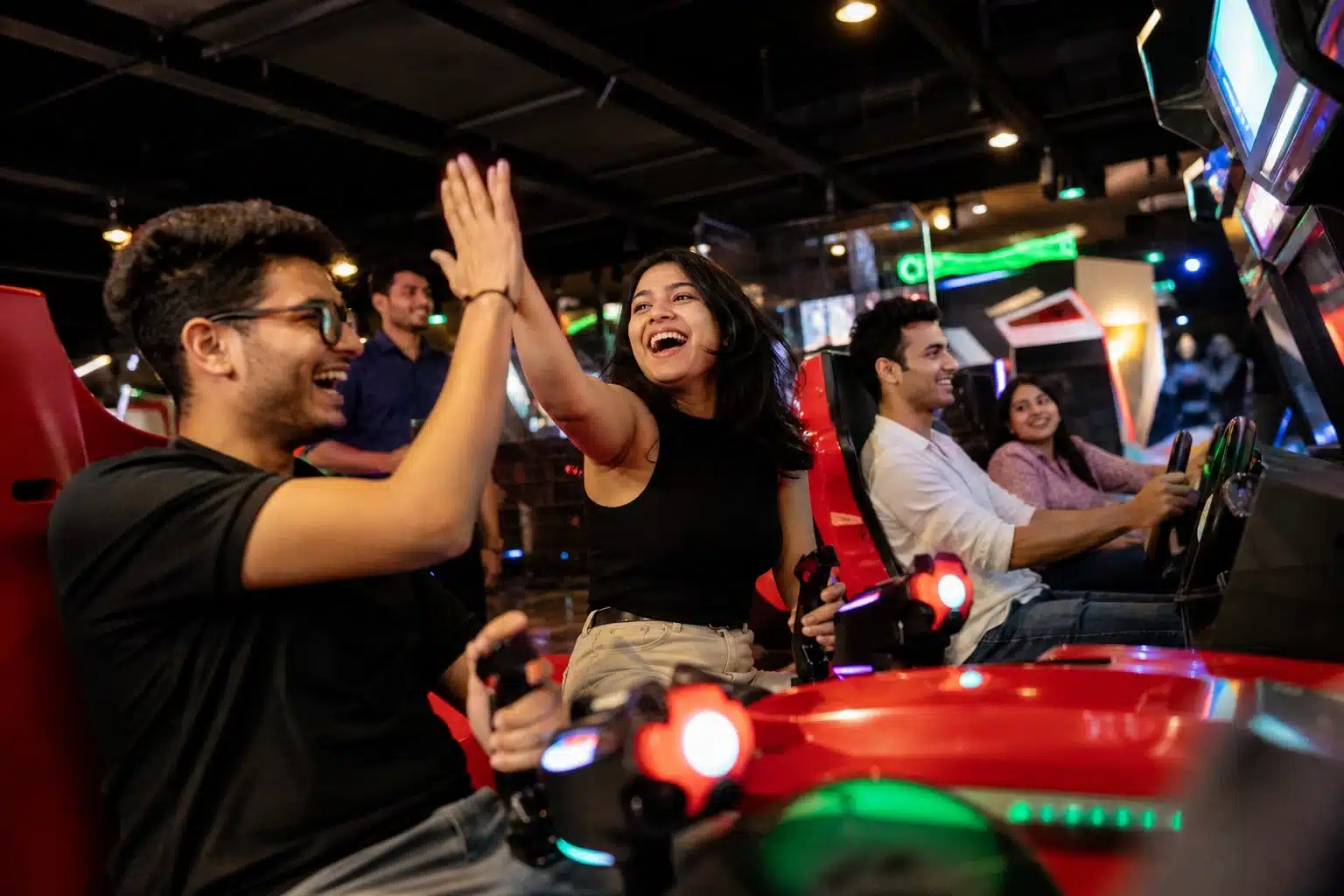 Friends playing arcade games at a busy game zone.